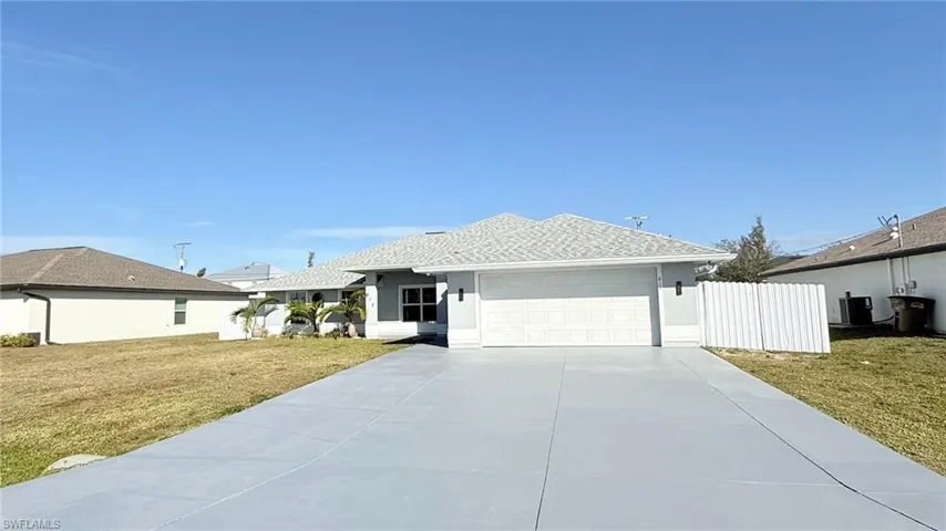 Ranch-style house with a front yard, concrete driveway, a garage, and a shingled roof