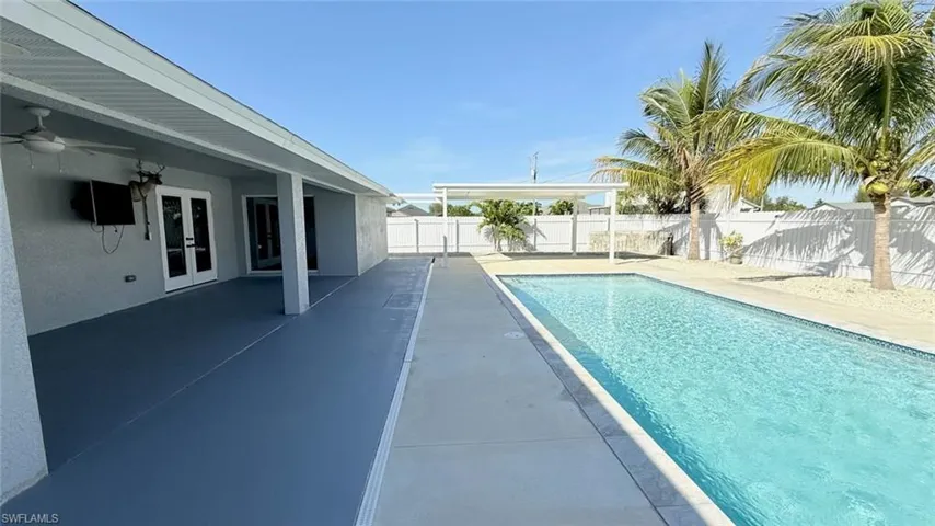 View of pool with french doors, a patio area, and a fenced backyard