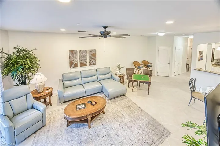 Spacious open-concept living area featuring light-toned flooring, recessed lighting, and a ceiling fan