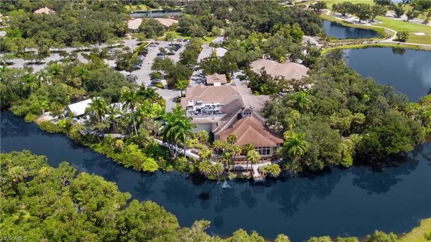 Resort-style property with a shingle-roof structure, surrounded by lush tropical landscaping and mature trees