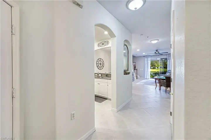 Archway entry featuring tile flooring, recessed lighting, white cabinetry, and a ceiling fan