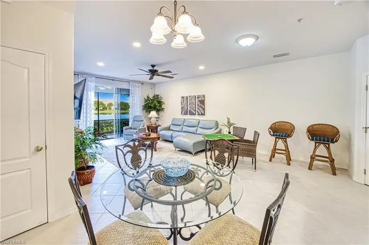 Open-concept living space featuring neutral tile flooring, recessed lighting, and a ceiling fan