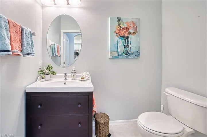 Bathroom featuring a white ceramic sink and dark wood-finish vanity with drawer pulls