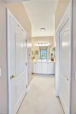 Hallway featuring neutral-toned walls and diamond-patterned tile flooring