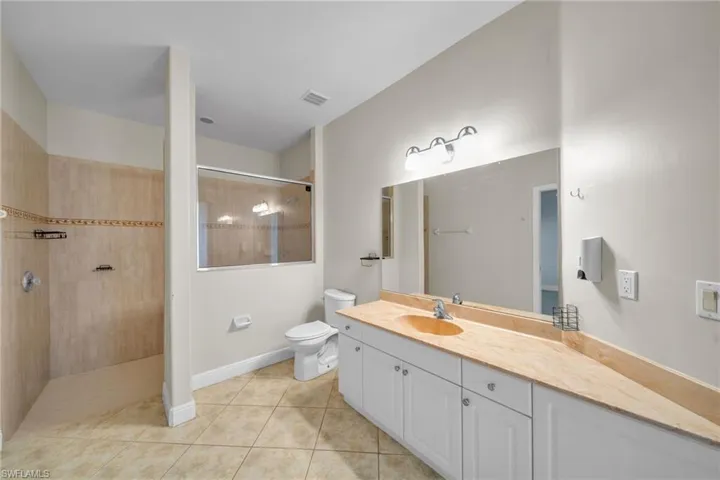 Full bathroom featuring vanity, light tile patterned floors, and a walk in shower