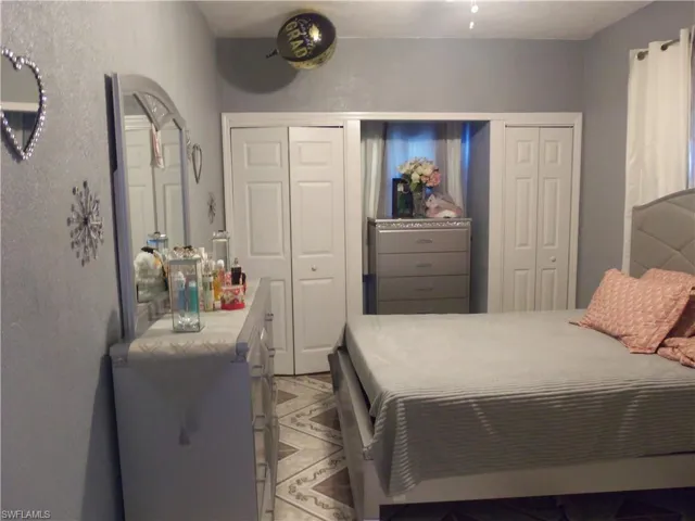 Tiled bedroom featuring multiple closets