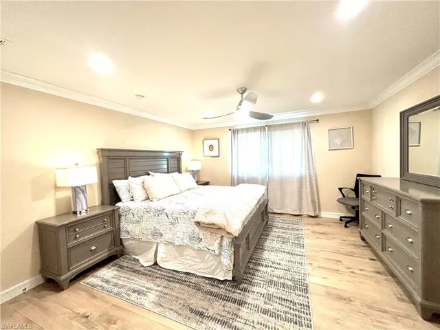 Spacious, nicely furnished primary Bedroom with light wood-style floors, a ceiling fan, and recessed lighting