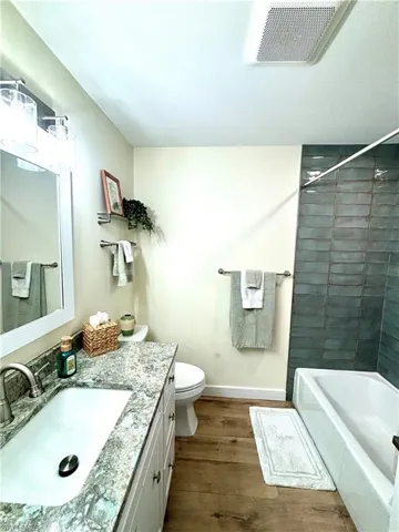 Bathroom featuring vanity, wood-style flooring, shower / bathtub combination