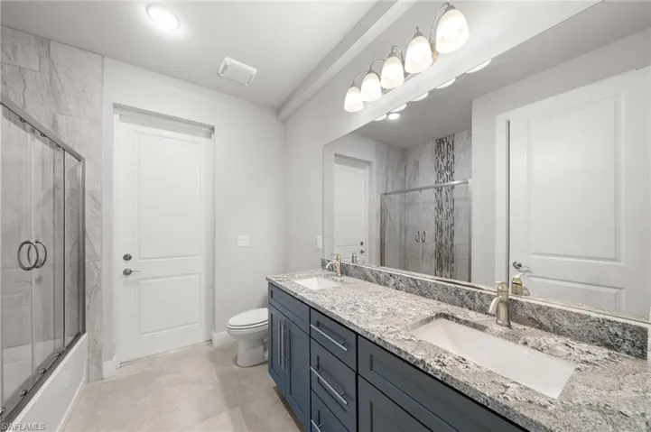 Laundry area featuring cabinet space, washer and dryer, and light tile patterned floors