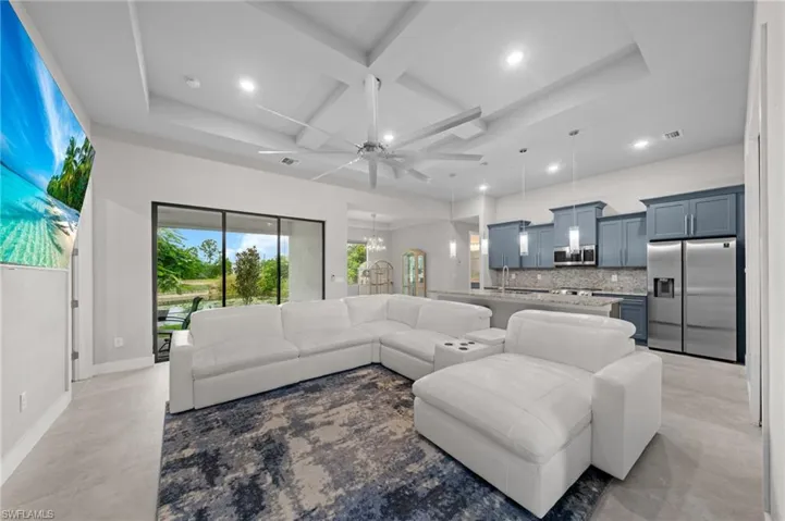 Kitchen with a kitchen breakfast bar, tasteful backsplash, decorative light fixtures, a center island with sink, and appliances with stainless steel finishes