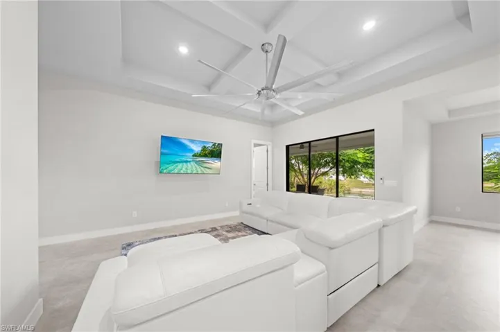 Living area featuring coffered ceiling, ceiling fan, beam ceiling, plenty of natural light, and recessed lighting