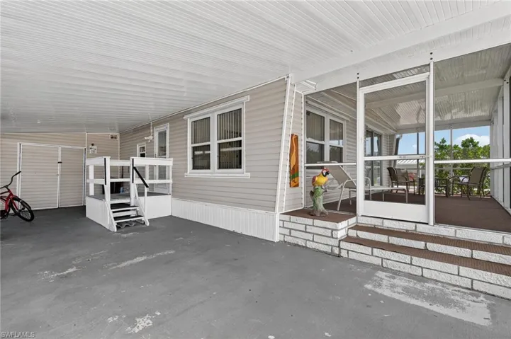 Covered Carport  with 2 entrances to home and 1 to workshop.