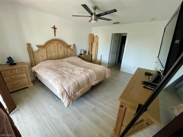 Bedroom with a ceiling fan, visible vents, and light wood-style flooring