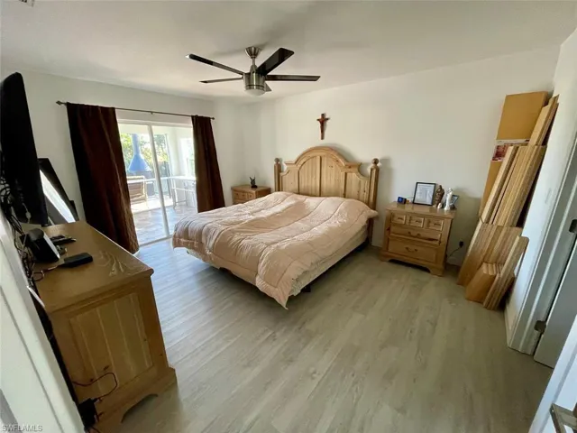 Bedroom with access to outside, light wood finished floors, and ceiling fan