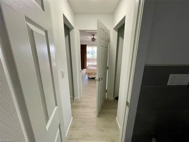 Hall with baseboards and light wood-style flooring