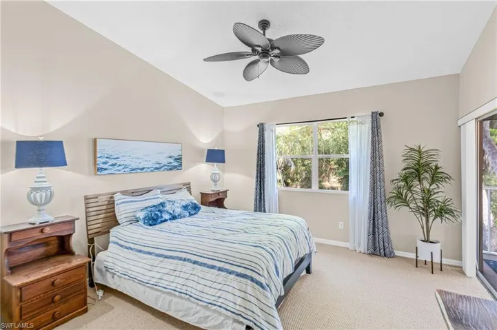 Carpeted bedroom with access to exterior and ceiling fan
