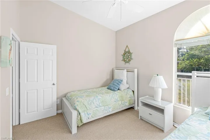 Carpeted bedroom featuring lofted ceiling and ceiling fan