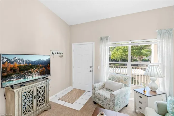 Living area featuring light carpet and baseboards