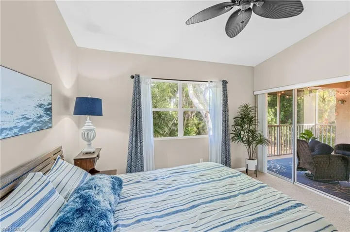 Bedroom featuring access to exterior, carpet floors, ceiling fan, multiple windows, and vaulted ceiling