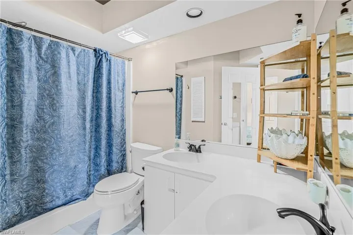 Full bathroom featuring double vanity and toilet