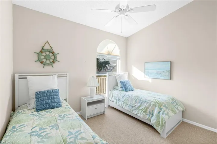 Bedroom with carpet, a ceiling fan, and a textured ceiling