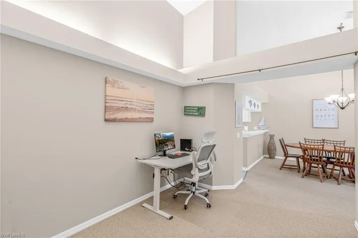 Office area featuring light colored carpet and a chandelier