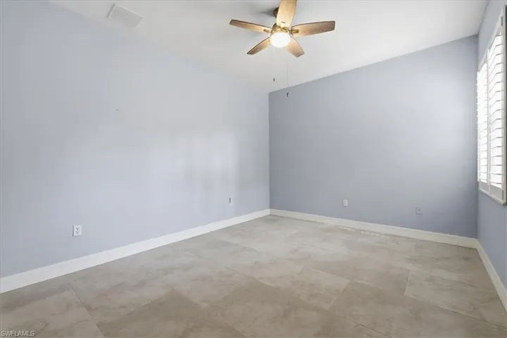 Spacious room featuring neutral tone flooring, light blue walls, and white trim