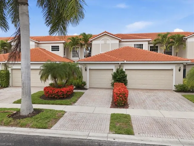 Mediterranean-style exterior featuring a terra cotta tile roof, neutral stucco siding, and multiple garage doors