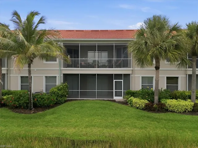 Two-story residence featuring a red tile roof and a neutral stucco exterior