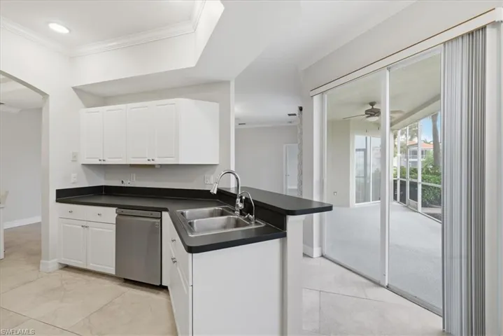 Kitchen area featuring white cabinetry, dark countertops, and stainless-steel appliances