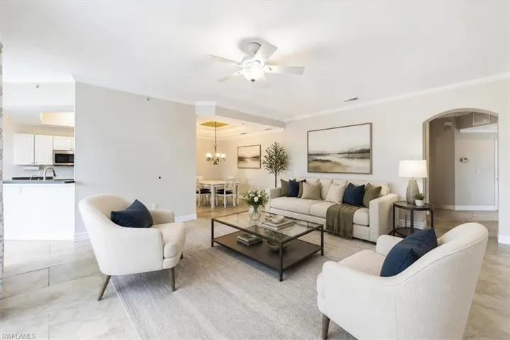 Spacious living area featuring neutral-toned walls, crown molding, and tile flooring