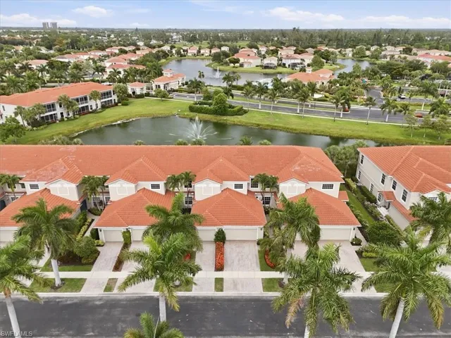 Aerial perspective highlighting properties with red tile roofs, multiple garage entries, and mature palm trees