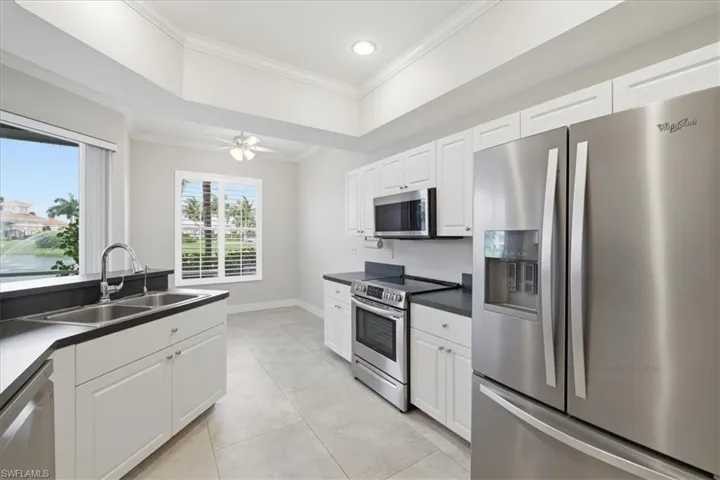 Contemporary kitchen featuring white cabinetry, dark countertops, and stainless steel appliances