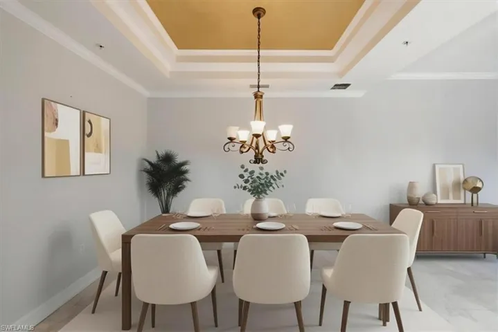 Spacious dining area featuring a tray ceiling with a gold-tone accent, crown molding, a decorative chandelier, and light-toned walls
