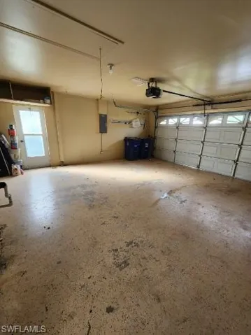 Garage featuring a garage door opener and electric panel