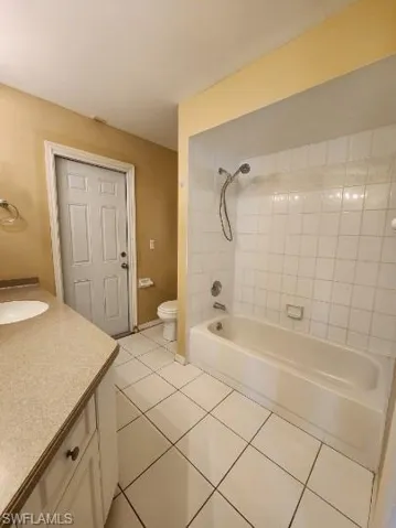 Bathroom featuring vanity, tub / shower combination, and light tile patterned floors