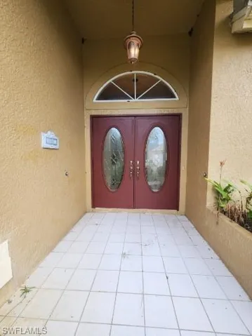 View of exterior entry with stucco siding, french doors, and a patio