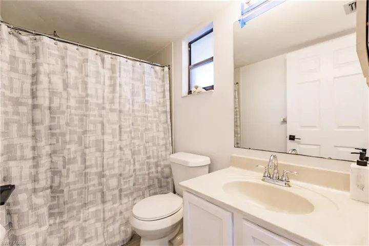 Full bathroom with a shower with curtain, vanity, and toilet