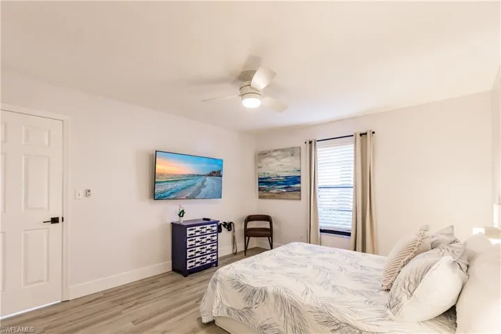 Bedroom featuring light wood-type flooring, a ceiling fan, and baseboards