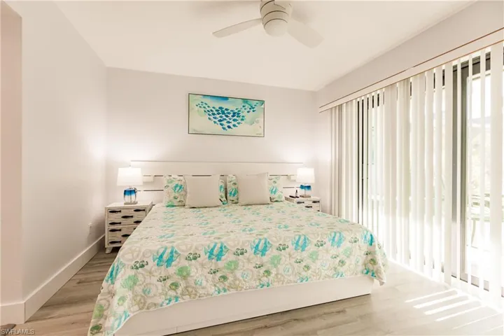 Bedroom with multiple windows, light wood-type flooring, a ceiling fan, and baseboards