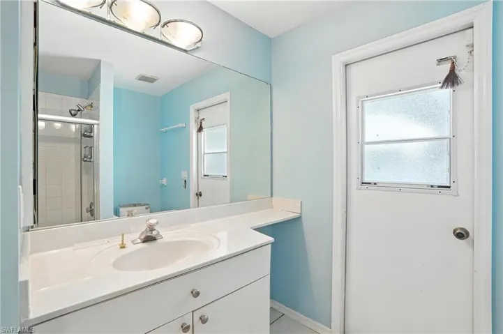 Full bath featuring vanity, a tile shower, and tile patterned floors