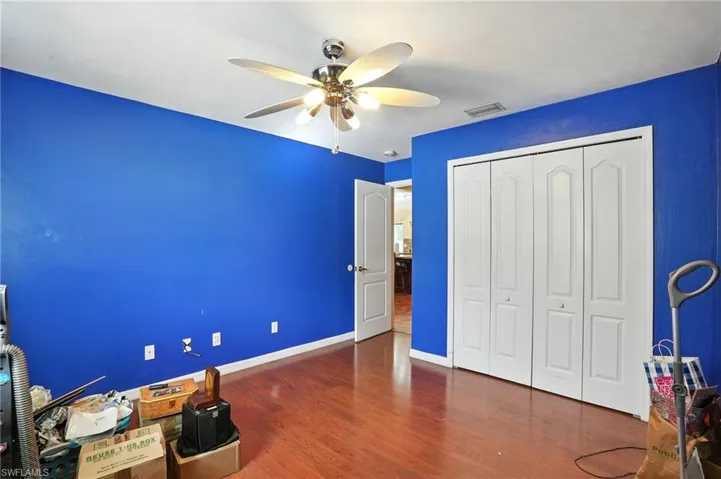 Bedroom with wood finished floors, a closet, and a ceiling fan