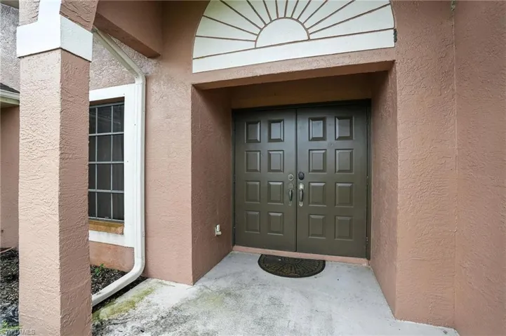 Entrance to property with stucco siding