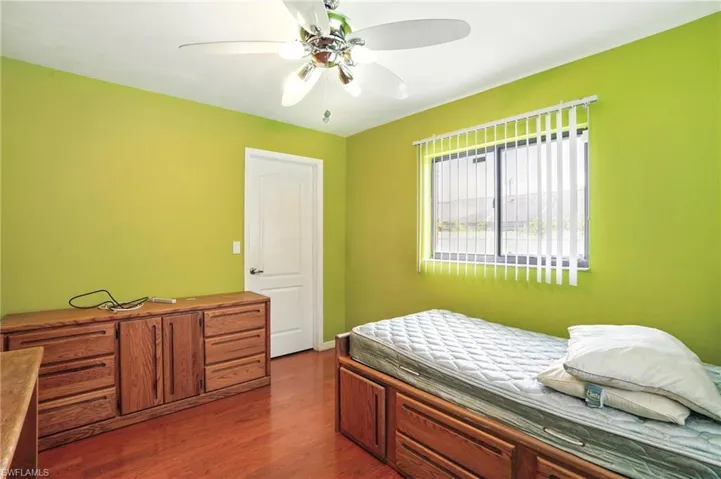 Bedroom with dark wood-style flooring and ceiling fan