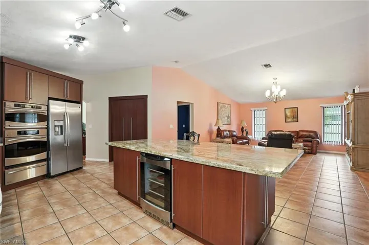 Kitchen featuring light tile patterned flooring, stainless steel appliances, beverage cooler, a chandelier, and a warming drawer