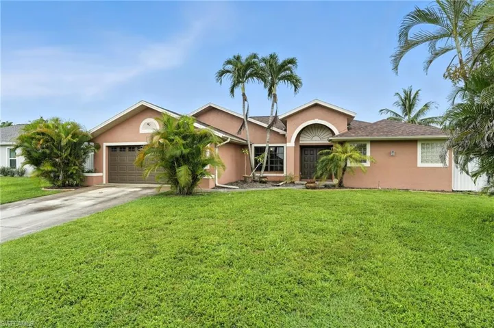 Ranch-style home featuring stucco siding, a front yard, an attached garage, and concrete driveway