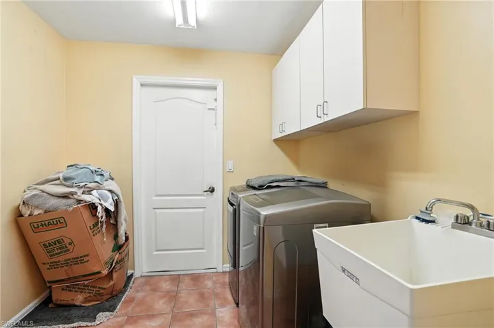Washroom featuring cabinet space, separate washer and dryer, and light tile patterned floors
