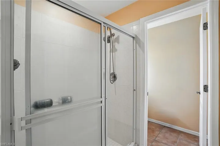 Full bathroom featuring a stall shower and tile patterned flooring
