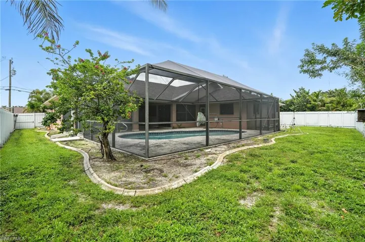 Back of house featuring a fenced backyard and a lanai