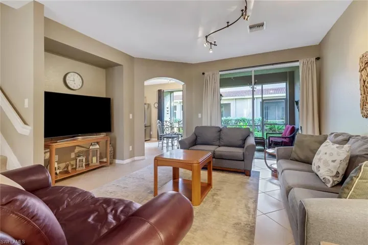 Living room with light tile floors and rail lighting